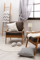Fototapeta na wymiar Cozy interior with armchairs, pillows and plaid near window