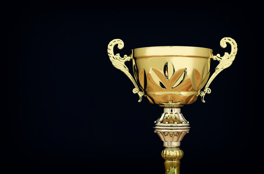 sports concept low key image of gold trophy over dark background