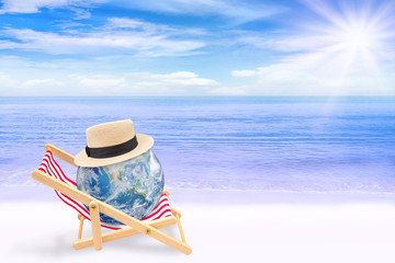Summer Vacation Concept : Abstract image of Blue planet earth globe laying relax on beach chair on sand beach with beautiful seascape view in background. (Elements of this image furnished by NASA.)