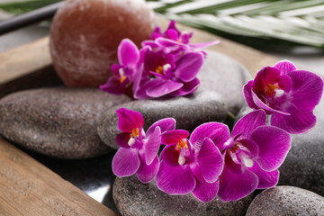 Spa stones and orchid flowers on tray, closeup