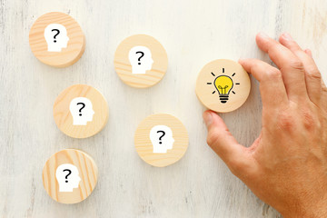 Business Concept image of revealing an idea, finding the right solution during creative process. Hand picking round cube with bright light bulb