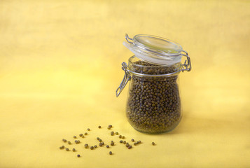 mung bean in a jar on a yellow background. Copy spaes.