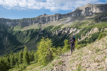 Fototapeta na wymiar Senior hiker ascending a trail in the Ecrins National park, French Alps