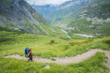 Senior backpacker walking toward the Vallonpierre hut, a very nice refuge in the Ecrins National Park, French Alps