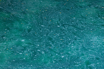 Karst lake in a mountain cave. Sulfurous lake. Beautiful natural texture and turquoise background of the lake combined with gold stone.