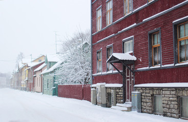 snowy winter scene in town. snowfall in a small street with colorful wooden houses in Estonia, Tallinn