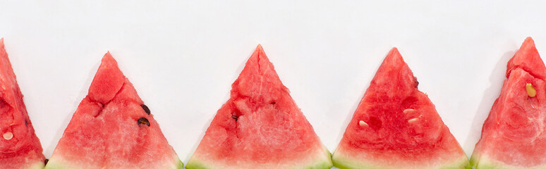 panoramic shot of fresh watermelon slices in row on white background