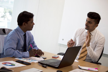 Two businessmen discussing project in conference room