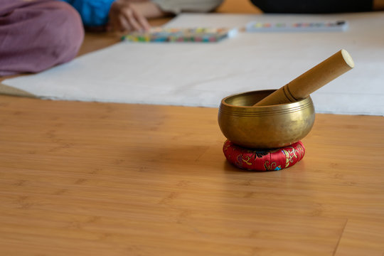 Brass bowl on the cloth base lay on the wood floor. It's the Asian vintage gimmick to ring a signal and sound for notice the seminar and workshop for attension to speaker.