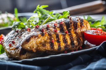 Chicken breast grilled with spices peper salt tomatoes and arugula