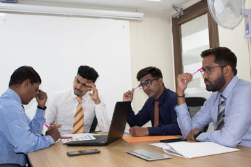 Group of worried business people in office boardroom meeting