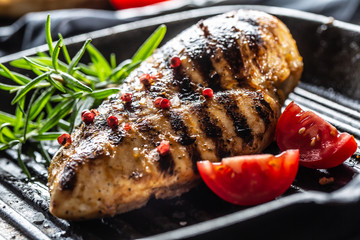 Chicken breast grilled with spices peper salt tomatoes and rosemary