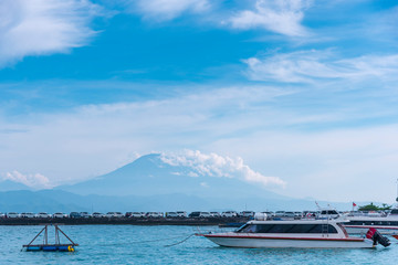 volcano Agung mountains of Bali view from nusa penida and sea and beach with car piar's penida island at in morning background
