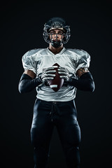 American football sportsman player in helmet on black background. Sport and motivation. Team sports.