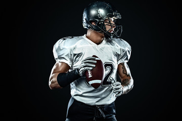 American football sportsman player in helmet on black background. Sport and motivation. Team sports.