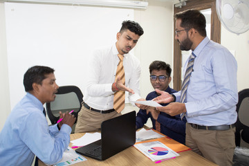 Businessmen arguing over a document at office meeting
