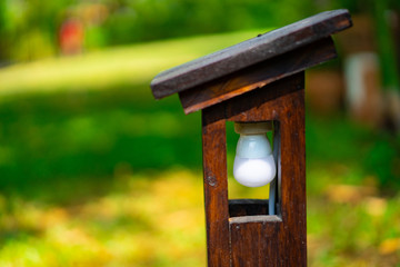 Vintage outside Wood lamp structure but inside is LED lamp settle in the garden.