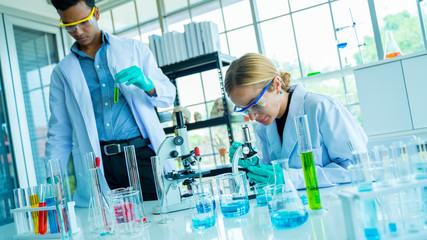 Two scientists conducting research in a lab environment.Analyze chemical formulas,biological test...