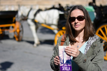 The girl in Seville in front of horse-drawn carriages