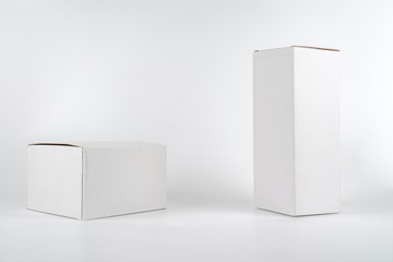 White two paper boxes - tall and fat lay on the white background in studio shot with clipping paht.