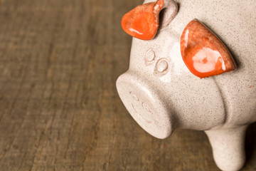 Piggy Bank on the old wooden table. Close up. The concept of saving money. Selective focus.