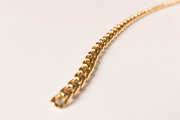 Gold plated chain on white background. Selective focus.