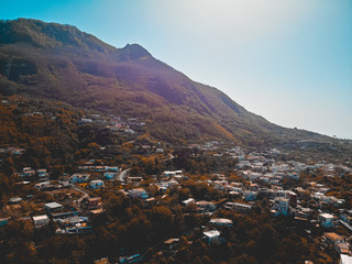 brown colored mountains at island with some housesbrown colored mountains at island with some houses