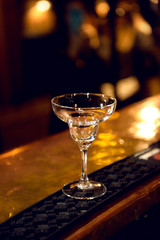 Close-up cocktail glass on a bar counter.