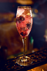 A non-alcoholic cocktail with red blackberries in a glass.