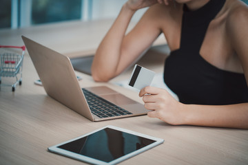 Naklejka premium Hand holding credit card and using laptop. Online shopping concept.Concept bank card.