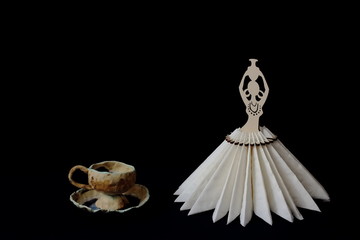 Exclusive clay tea pair decorated with glaze and elegant stylized stand for napkins on black background. Minimal style. Concept - serving, decor, tea, restaurant, cafe.