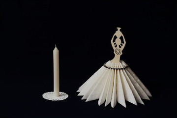 Elegant vintage stylized napkin stand and wax candle on white lace napkin on black background. Minimal style. Concept - serving, decor, restaurant, cafe.