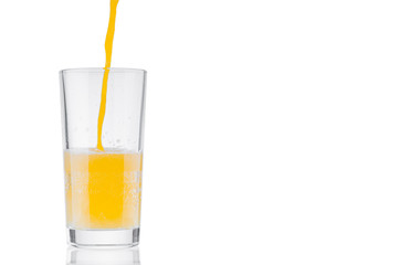 Pouring orange juice in glass on white background