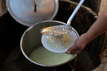 CRETE, GREECE. JUNE 2019. Production of feta cheese. The cheese is placed on a plate from a stainless steel strainer to cool.