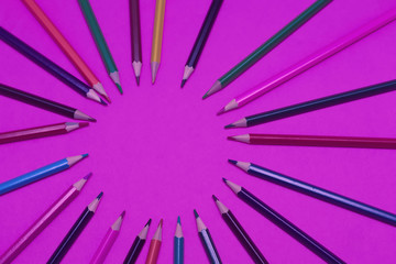 Obraz premium Many colored pencils lie on a neon background. Copy spase. The concept of back to school, the educational process, study at school, drawing