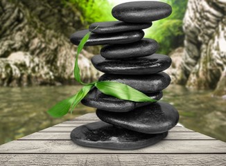 Zen basalt stones and leaves on background