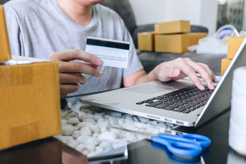 Small business parcel for shipment to client, Young man received online shopping parcel opening boxes and buying items by credit card, online marketing on purchase order package product