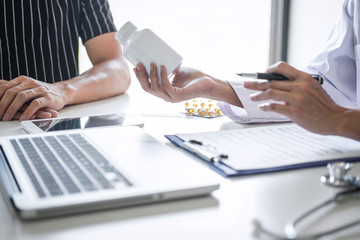 Doctor consulting patient discussing something symptom of disease and recommend treatment methods, presenting results on report and prescription, Medicine and health care concept