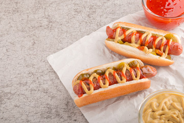 Hot dog with grilled sausage  mustard  and ketchup  onions  and greens on Paper background