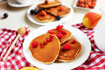 Healthy summer breakfast,homemade classic american pancakes with fresh berry and honey, morning light white stone background copy space top view