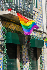Rainbow flag of the LGBT community blown in the wind on the building. Love, freedom, equality of rights concepts.