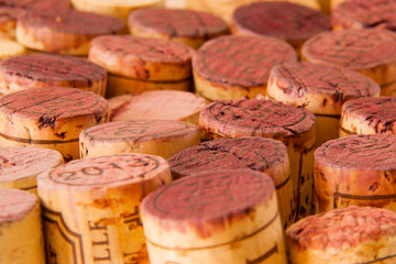 Close-up of multiple wine corks, mainly red wine.