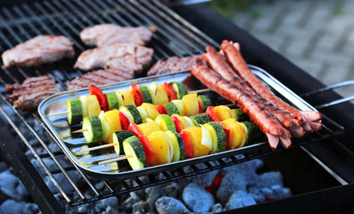 Vegetable skewers, sausages and steak on the grill