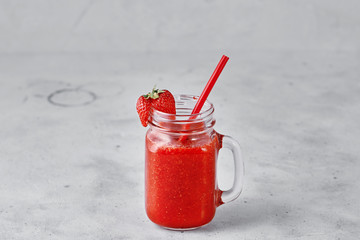 Strawberry smoothie in cup on white concrete background