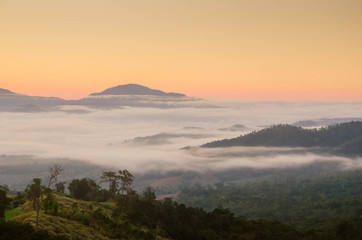 Fototapeta na wymiar Fog and complex of mountain landscape with colorful twilight.