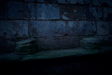 A dark and spooky background of two old and worn plinths on a stone shelf in the ruins of an old...