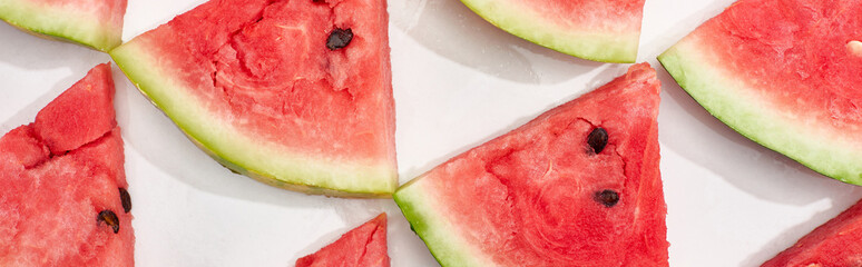 panoramic shot of delicious fresh watermelon slices in rows on white background