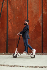 Bearded male riding electric scooter