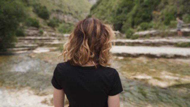 Woman standing by river stream in Nature Reserve Cavagrande, Sicily