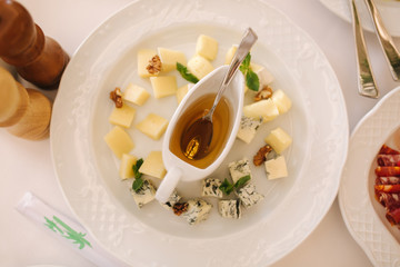 Appetizer in restaurant. Banquet concept. Plate with cheeses with honey. parmesan, brie, camembrt, maasdam. top view